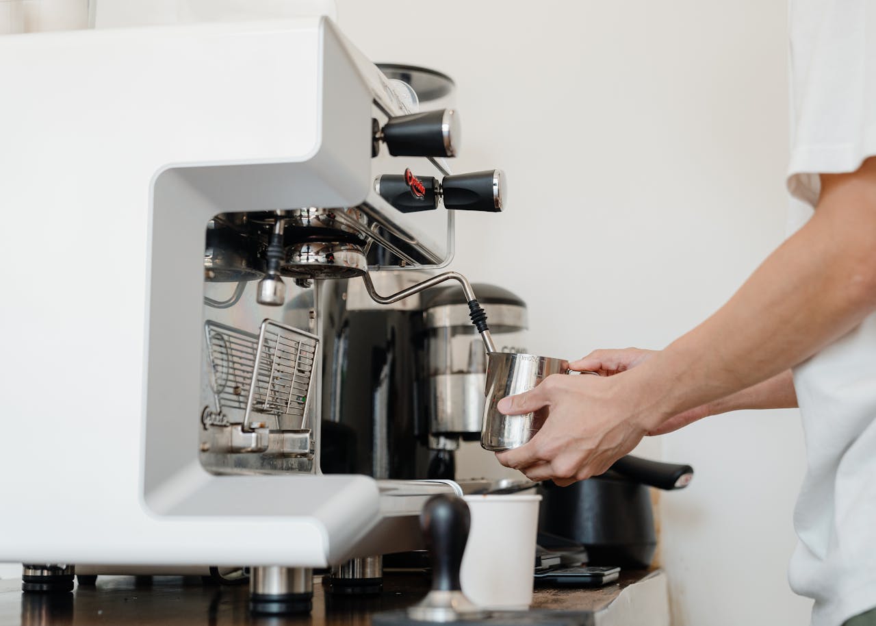 Home Close-up of a barista's hands using a coffee machine to make espresso indoors.